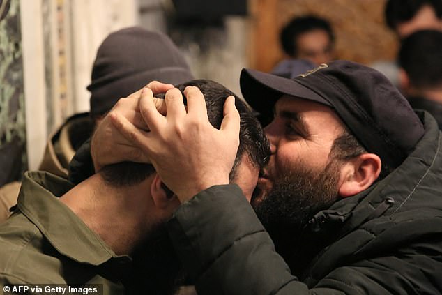 A supporter kisses the forehead of Abu Mohammed al-Jolani, upon his arrival inside the emblematic Umayyad Mosque in the Syrian capital.