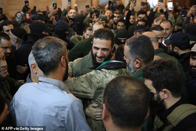 Abu Mohammed al-Jolani (center), hugs his followers before his speech at the capital's emblematic Umayyad Mosque.