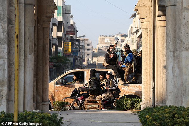 Anti-government fighters patrol the streets of Hama after capturing the central Syrian city, December 6.