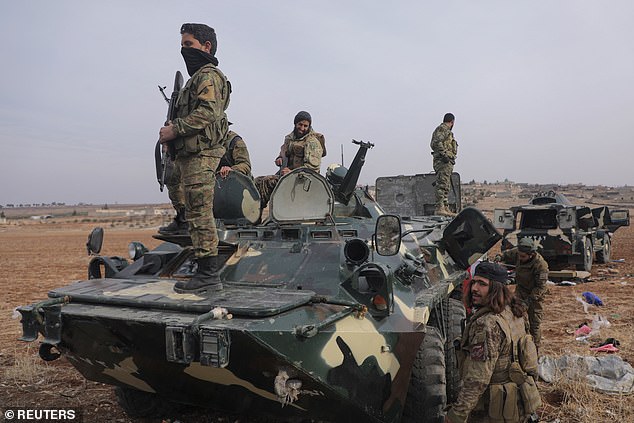 Rebel fighters stand in a military vehicle in the countryside of Homs, after Syrian rebels pressed their lightning advance on Saturday.