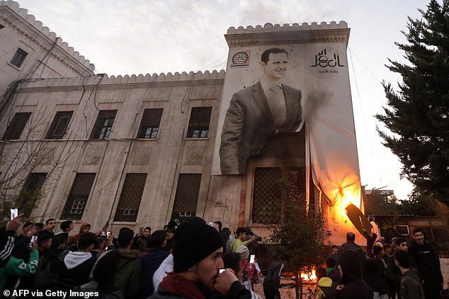 Residents of Hama set fire to a large banner with the image of Syrian President Bashar al-Assad hanging on the facade of a municipal building.