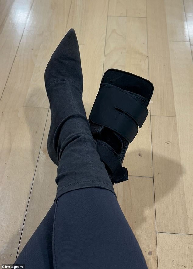 The Kardashian star, 44, took to her Instagram Story to share an image of her left foot in a boot cast while modeling a single black heel on her right.