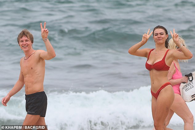 The couple looked happy and relaxed as they headed to the water, chatting and smiling as they held up peace signs for photographers.