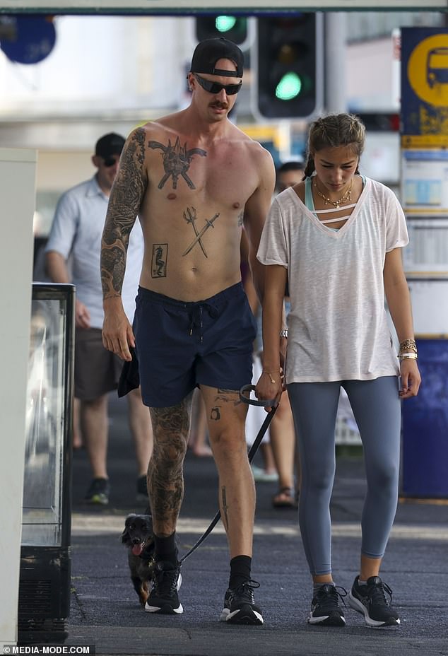 His stunning new lover proudly flaunted his tattoos on his sleeves, legs and chest while going shirtless in a pair of shorts and sneakers.