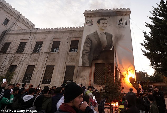 Residents of Hama set fire to a large banner with the image of Syrian President Bashar al-Assad hanging on the facade of a municipal building.