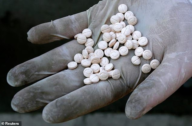 A customs officer shows Captagon pills, part of the 789 kilograms of drugs seized, before they are burned in Sofia, 12, 2007