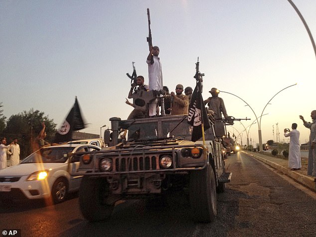 In this June 23, 2014, file photo, Islamic State group fighters parade in an Iraqi Security Forces armored vehicle in the northern city of Mosul, Iraq.