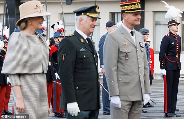 The monarch, dressed in an elegant checkered coat, was accompanied by her husband, King Philip, on the visit to the school in the French region of Brittany.