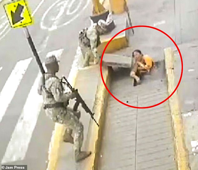 A soldier removes Elvira Taipe's concrete slab moments after the mother of two fell to the ground and landed under the pavement after an underground electrical box exploded in Lima, Peru, last Thursday.