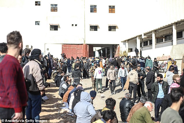 People wait today as teams carry out an investigation in secret compartments of the Sednaya prison after the fall of the Assad regime in Damascus.