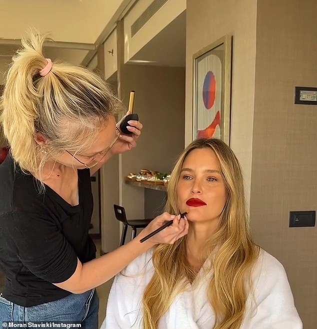 In behind-the-scenes footage, makeup artist Moran Staviski could be seen applying a bold, vampy red lip to Refaeli.