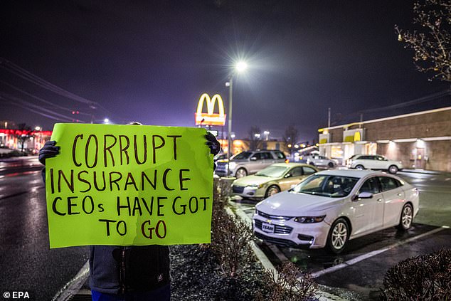 A woman, who did not want to be identified and who works in health care, held a protest sign outside the McDonald's restaurant where Altoona police arrested Luigi Mangione on Monday.