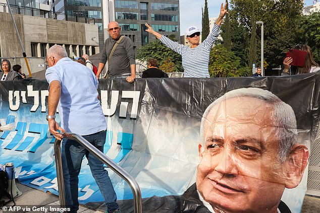 Protesters raise a banner and placards at a demonstration in support of Israel's Prime Minister Benjamin Netanyahu during his trial on corruption charges.