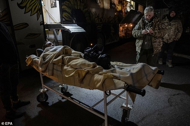 Hospitallers medical staff transport an injured Ukrainian soldier on their medical bus for transport to a hospital in the Donetsk region.