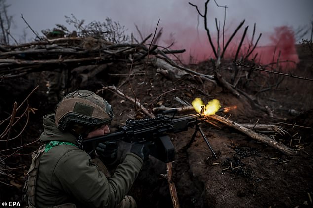 A serviceman from the 24th Mechanized Brigade of the Armed Forces of Ukraine fires his weapon in the Donetsk region, eastern Ukraine.