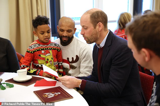 William is seen chatting with families at the barracks today.