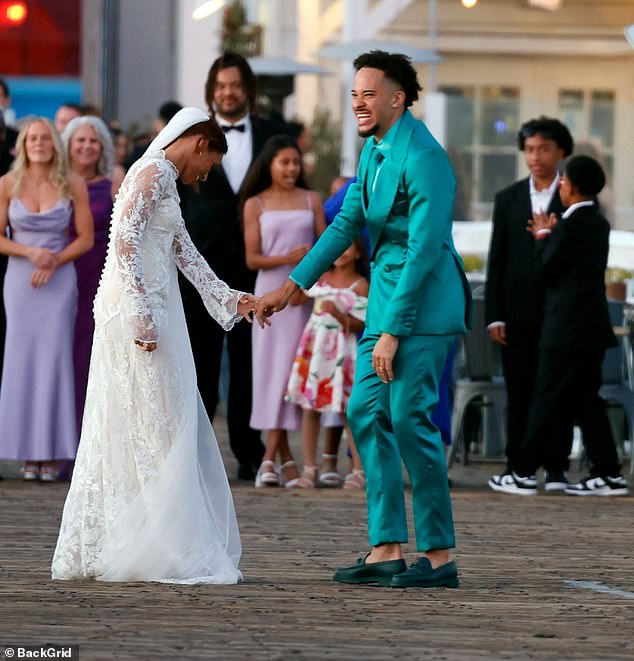 Meanwhile, his girlfriend Lynn looked every inch the blushing bride in a stunning white lace dress with a high neck and cascading sleeves.