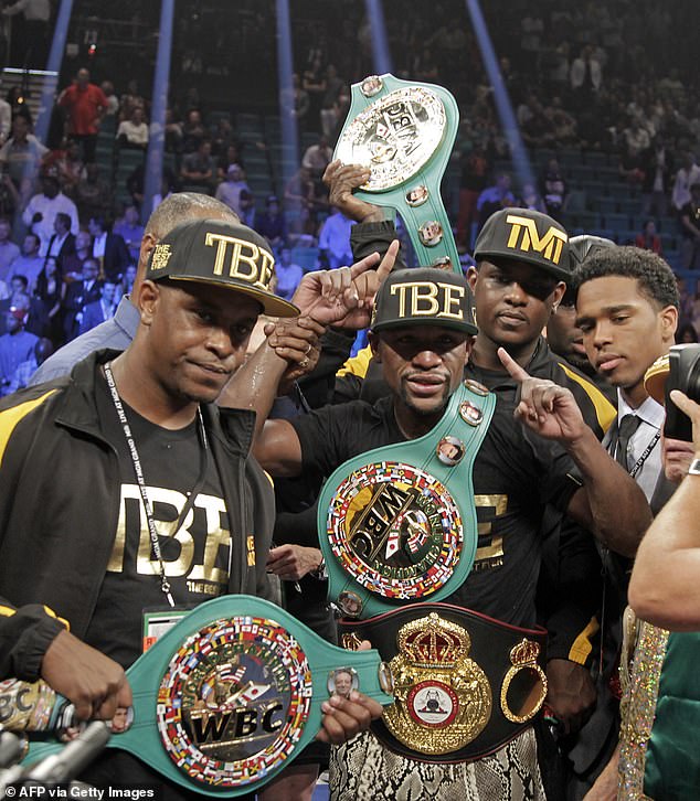 Floyd Mayweather (center) poses with his belt after beating Marcos Maidana in 2014