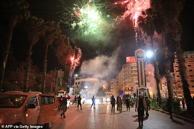 Syrians celebrate in the main square of Homs in the early hours of December 8.