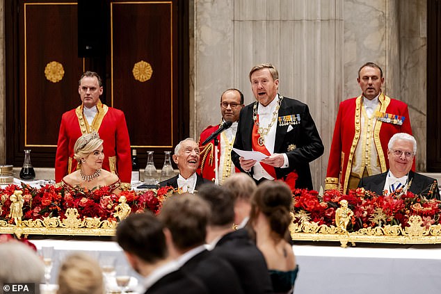 The royal, 53, struck a glamorous chord in the scarlet dress, embellished with gold and black details, as she welcomed Marcelo Rebelo de Sousa at the royal palace in Amsterdam.