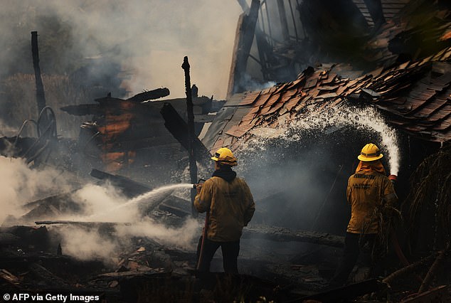 Fire crews sprayed water on the Franklin Fire Tuesday morning as other parts of the blaze rapidly grew larger by the minute