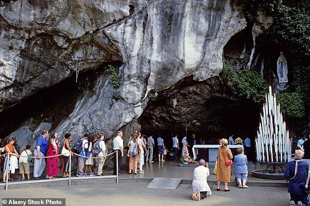 File image of pilgrims visiting the statue of Our Lady of Lourdes in the Massabielle cave, Lourdes, France