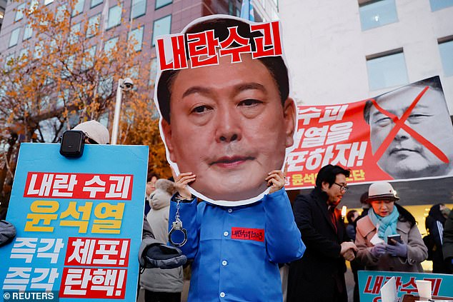 A protester carries a cutout of the president's face. In a somewhat rare development, Rodong Sinmun, the official newspaper of North Korea's ruling party, published a detailed report on last week's tumultuous events in Seoul, including photographs of the protests.