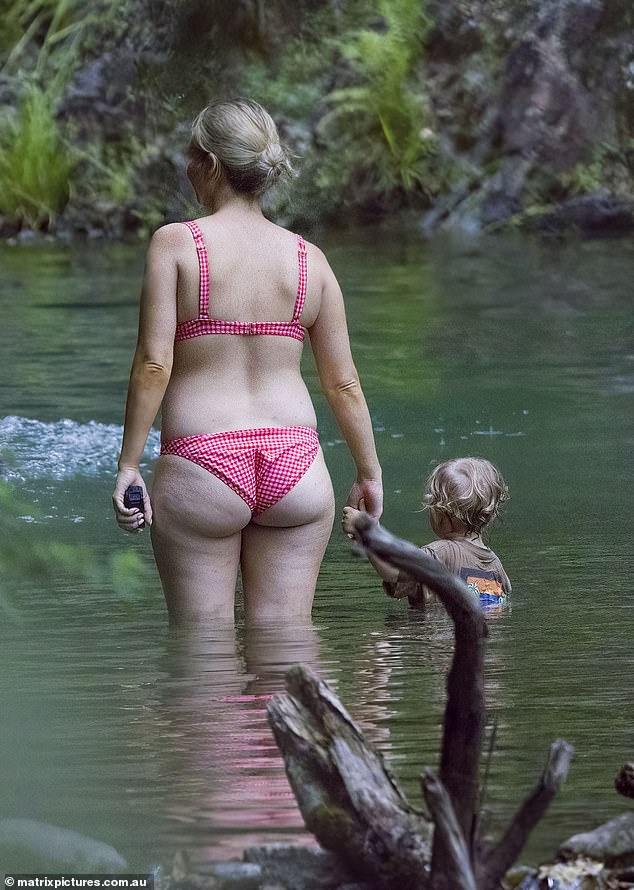 At one point, Sam flaunted her perfectly toned butt as she happily strolled through the shallow, clear water.