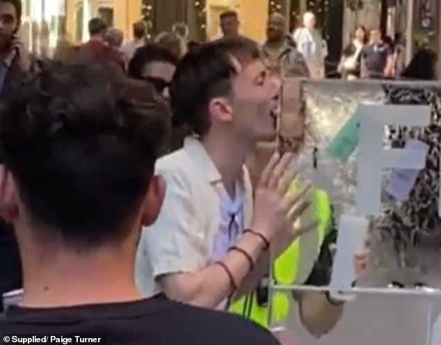 Security guards came to his aid and one of them poured water into his open mouth (pictured).