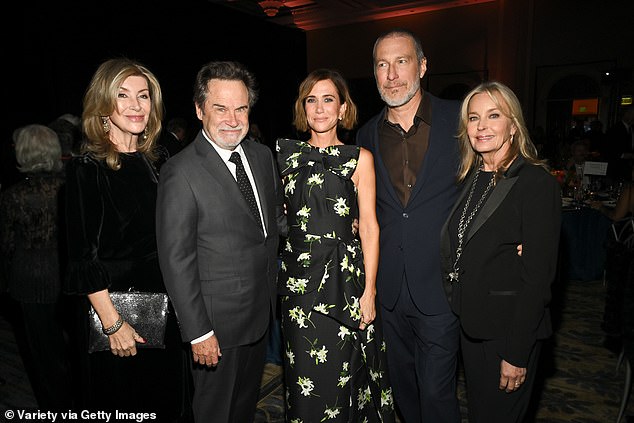 The Sex and the City star, 63, wore a sharp navy suit with a khaki shirt underneath and smart shoes (LR Carolyn Espley, Dennis Miller, Kristen Wiig, John ad Bo)