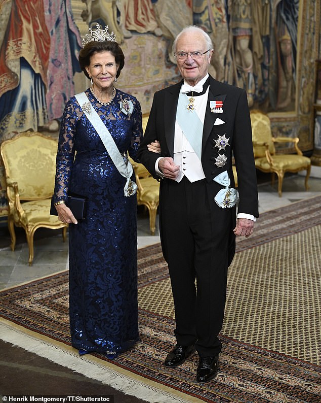 Queen Silvia (pictured with husband King Carl Gustaf XVI) matched her daughter in a midnight blue, embroidered and bejeweled floor-length dress