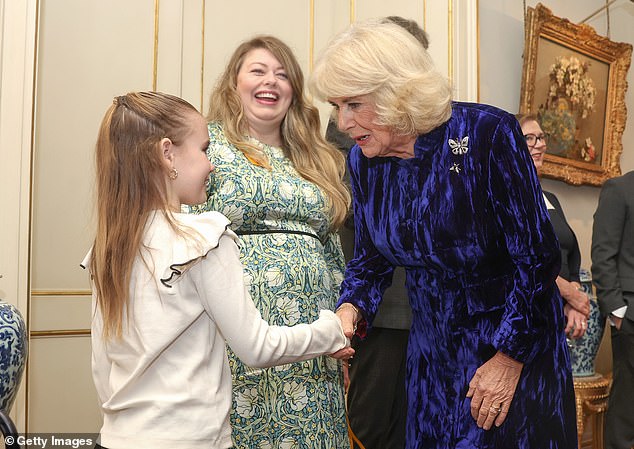 Camilla shook the hand of a little girl as she welcomed children and families supported by Helen & Douglas House and Roald Dahl's Marvelous Children's Charity, to decorate a Christmas tree.