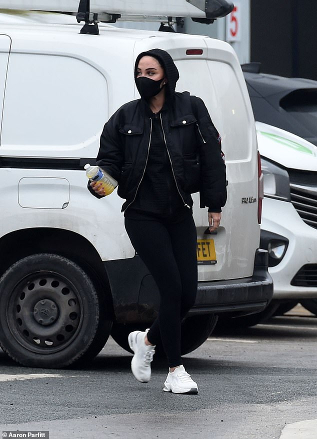 Tulisa walked through the parking lot carrying a bottle of orange juice.