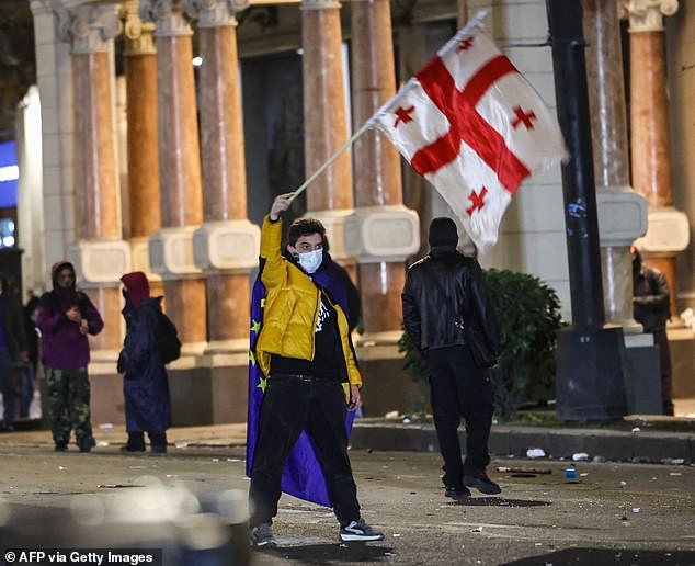 Protesters clash with police during a demonstration against the government's decision to delay European Union membership talks amid a post-election crisis, in front of Georgia's Parliament in Tbilisi, early December 1, 2024.