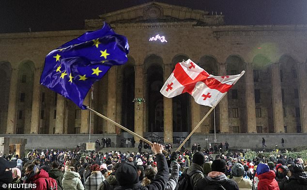 Supporters of Georgia's opposition parties hold a rally to protest against the government's decision to suspend talks on accession to the European Union, in front of the parliament building.