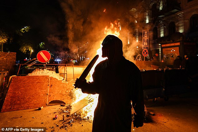 Protesters light a fire at the base of a makeshift barricade erected on a Tbilisi street during demonstrations against the government's decision to delay European Union membership talks.