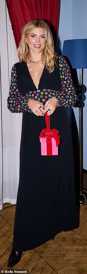 The host and model completed her look with a pair of black boots and added a fun pink and red gift boxed clutch to her colorful look.