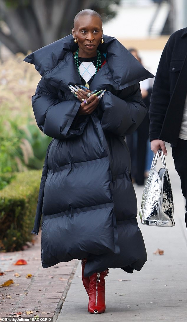 The fashionista kept comfortable in a long, oversized black puffer jacket with an exaggerated collar.