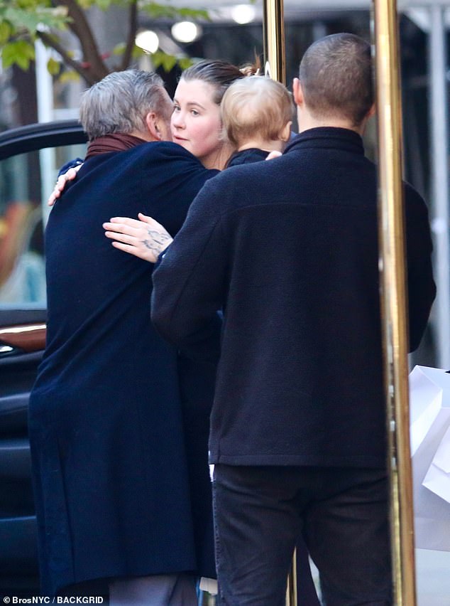 The father and daughter shared a hug as her partner and child looked on