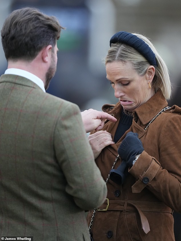 She completed the look with simple black pants and matching boots. Zara also donned some gloves to stay warm in the cold December weather. Another guest at the races appeared pointing at the Zara jersey