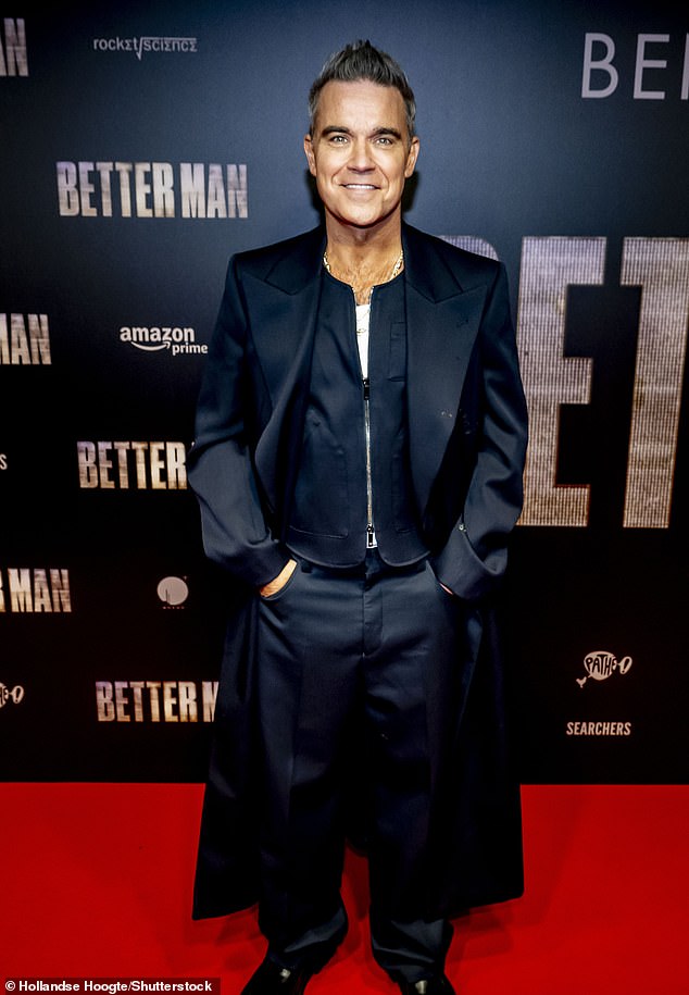 Robbie looked dapper on the night in a stylish navy jacket which he teamed with matching trousers and a long coat.