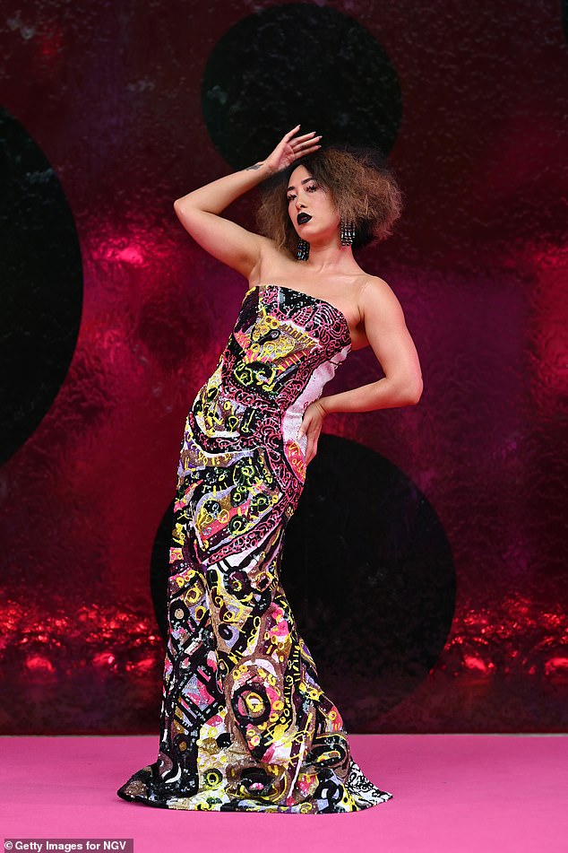 The former MasterChef Australia star struck some theatrical poses as she showed off her multicolored strapless column dress in a neon graffiti style.