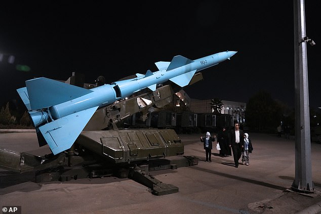 People walk past a domestically-made Iranian missile while visiting the Revolutionary Guard National Aerospace Park, outside Tehran, Iran, on November 15 this year.