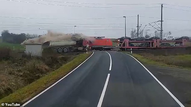 The freight train, carrying several new Audi cars, collided with the truck and was dragged at high speed, while the driver desperately tried to brake.