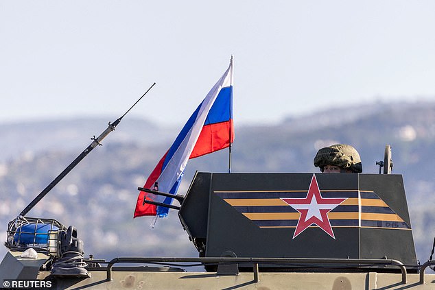 A Russian soldier rides in an infantry fighting vehicle in Latakia, on the coast of Syria.