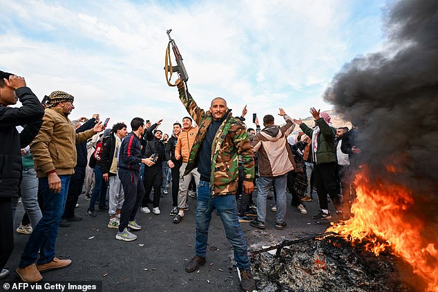 People celebrate in Damascus' Umayyad Square on December 8, 2024, as rebel soldiers declare they have taken the capital.