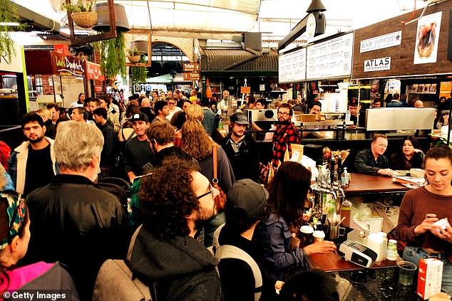 Authorities have warned anyone with cold or flu symptoms to stay home and wear masks in crowded public places. Pictured are crowds at Fremantle Markets.