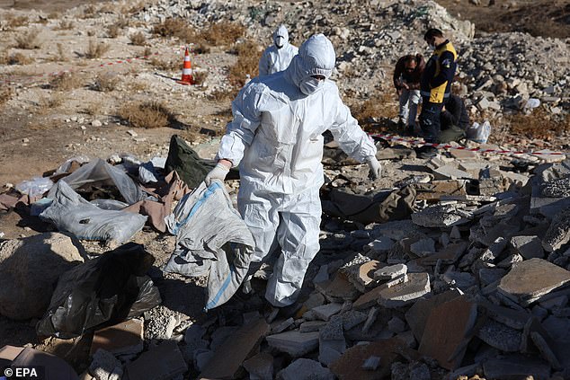 Members of the Syrian Civil Defense group, the White Helmets, work at the site where several bodies and human bones were discovered