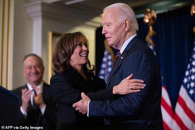 US Vice President Kamala Harris hugs US President Joe Biden before speaking during the Democratic National Committee holiday reception i