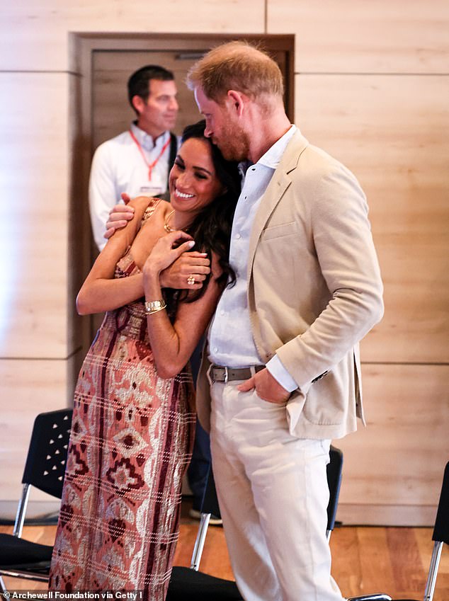 Prince Harry places a kiss on Meghan's forehead in a photo taken during their four-day visit to Colombia in August.